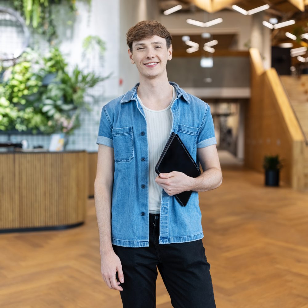 Young person standing with a tablet, ready to start work